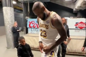 这个我也想要！小球迷拿着詹姆斯球衣 后者特意停步为他送上亲签